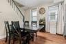 Dining space featuring light wood-style floors and stacked washer / dryer. Stairs leading to 2nd floor
