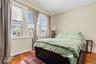 Spacious Bedroom featuring hardwood floors, large windows for natural light and baseboards