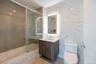 Full bath with vanity, tile walls, toilet, and shower / bath combination with glass door