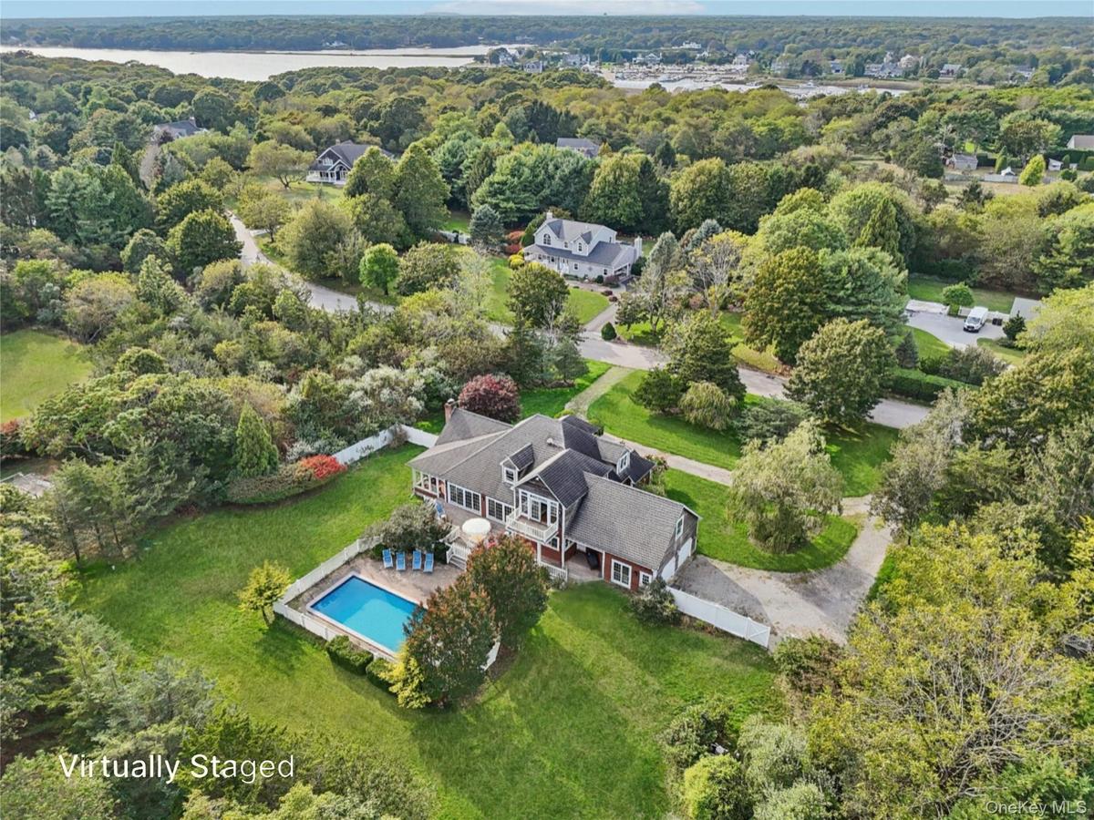 A captivating aerial perspective showcasing the property’s rear elevation, where architecture and landscape blend in perfect harmony. Virtually Staged