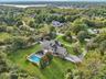 A captivating aerial perspective showcasing the property’s rear elevation, where architecture and landscape blend in perfect harmony. Virtually Staged