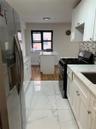 Kitchen featuring range with gas cooktop, white cabinetry, light marble finish floors, stainless steel refrigerator with ice dispenser, and decorative
