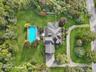 A breathtaking aerial view capturing the full scope and beauty of the property. Virtually Staged to show open pool. Virtually Staged to show open pool