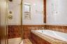 Full bath featuring tile walls, a garden tub, and a stall shower