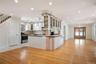 Kitchen featuring a sink, light wood-type flooring, glass insert cabinets, appliances with stainless steel finishes, and ornamental molding