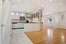 Kitchen with stainless steel appliances, dark countertops, baseboards, decorative backsplash, and white cabinetry