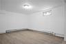 Empty room featuring a baseboard heating unit and wood finished floors