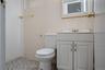 Bathroom featuring tile walls, tile patterned floors, vanity, and toilet