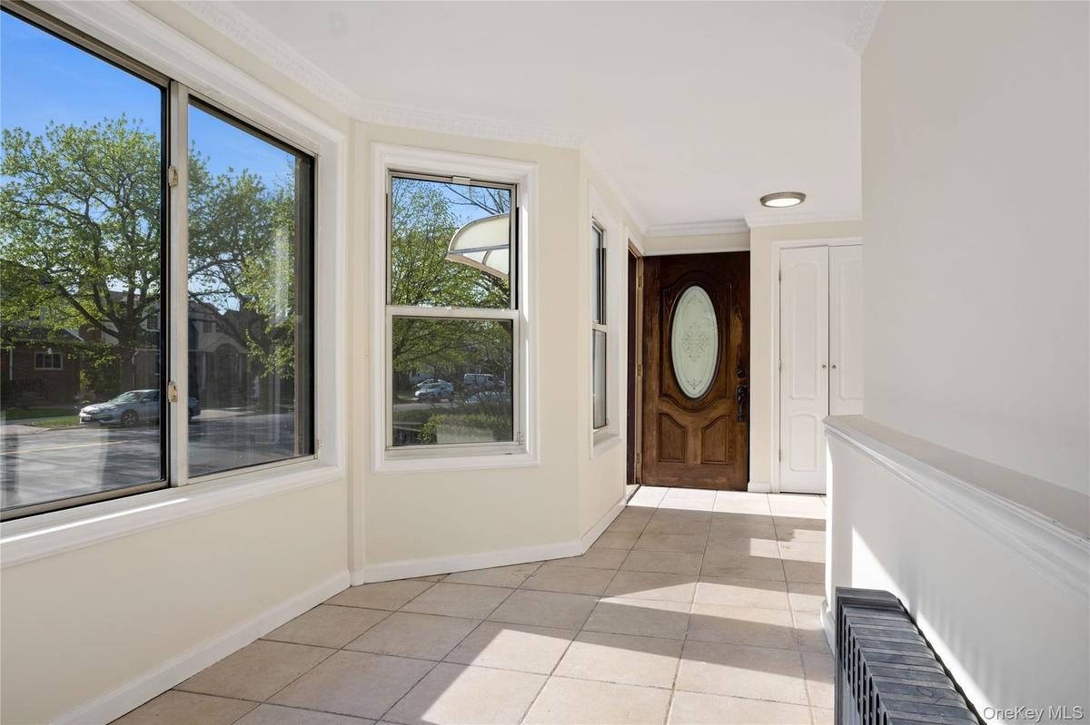 Foyer with baseboards and light tile patterned floors