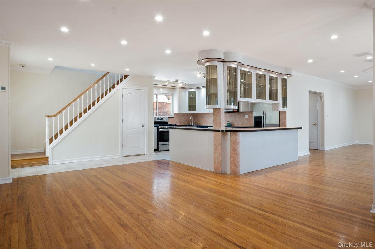 Kitchen featuring decorative backsplash, crown molding, dark countertops, baseboards, and stainless steel appliances