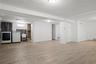 Below grade area featuring a baseboard heating unit, washing machine and clothes dryer, wood finished floors, and a sink