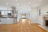 Kitchen featuring crown molding, a fireplace, white cabinets, stainless steel microwave, and light wood-style floors