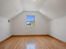 Additional living space featuring baseboards, visible vents, light wood-style floors, and vaulted ceiling