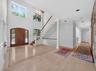 Entryway with arched walkways, stairs, light wood-style flooring, a wainscoted wall, and a decorative wall