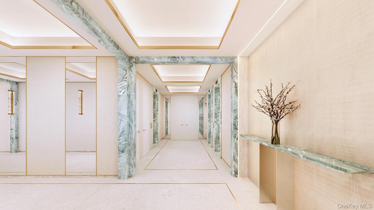 Corridor with tile patterned flooring and a tray ceiling