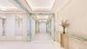 Corridor with tile patterned flooring and a tray ceiling