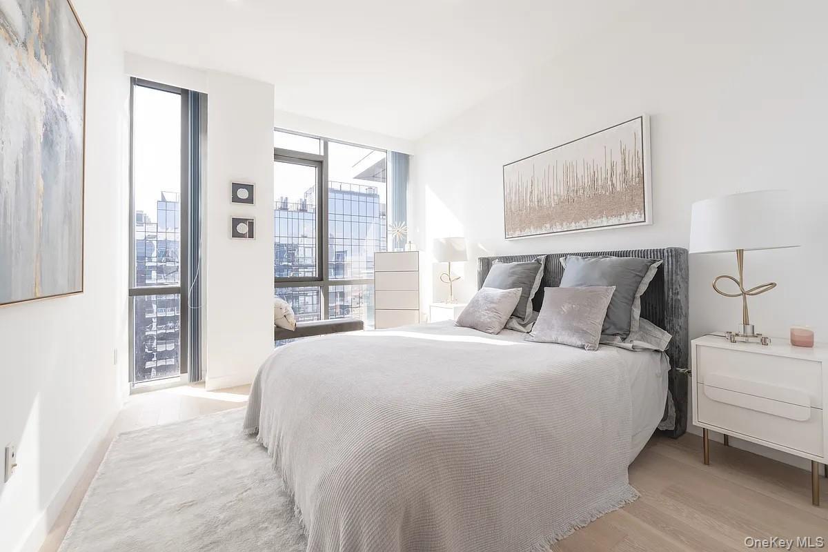 Bedroom featuring floor to ceiling windows and light wood-style floors