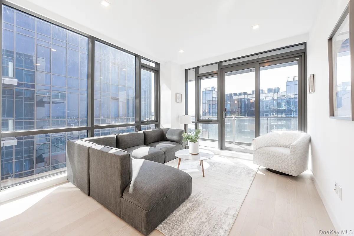 Living area with a view of city, wood finished floors, and floor to ceiling windows