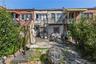 Back of house featuring brick siding, a balcony, a patio area, and stairs