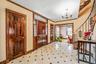 Entryway with stairway, ornamental molding, a chandelier, and light flooring