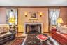 Living area featuring wood finished floors, a premium fireplace, and crown molding