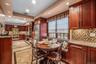 Kitchen with light stone counters, backsplash, reddish brown cabinets, stainless steel appliances, and recessed lighting