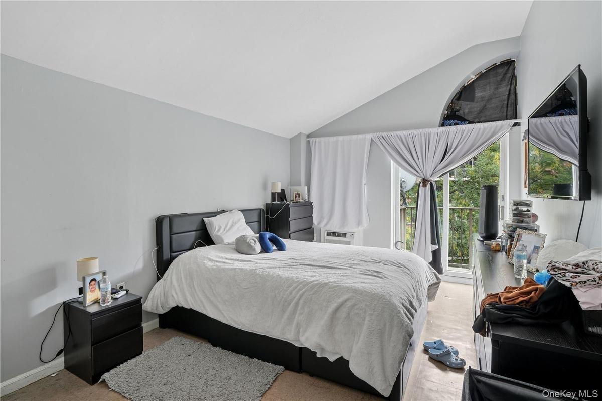 Bedroom with access to exterior and vaulted ceiling