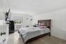 Bedroom with a baseboard heating unit, a textured ceiling, lofted ceiling, tile patterned floors, and an AC wall unit