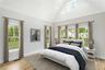 Primary Bedroom Staged featuring high vaulted ceiling, multiple windows, and light wood finished floors