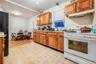 Kitchen featuring white range with gas cooktop, light wood-type flooring, and black fridge