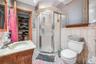 Bathroom with vanity, tile walls, toilet, and walk in shower