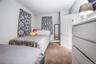 Carpeted bedroom with a baseboard radiator