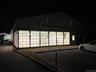 Corner showroom presence with full-height glazing and illuminated frontage.Strong nighttime visibility reinforcing retail and industrial brand exposur