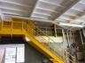 Steel mezzanine access with dedicated stair system.Elevated office / storage component maximizing vertical utility.