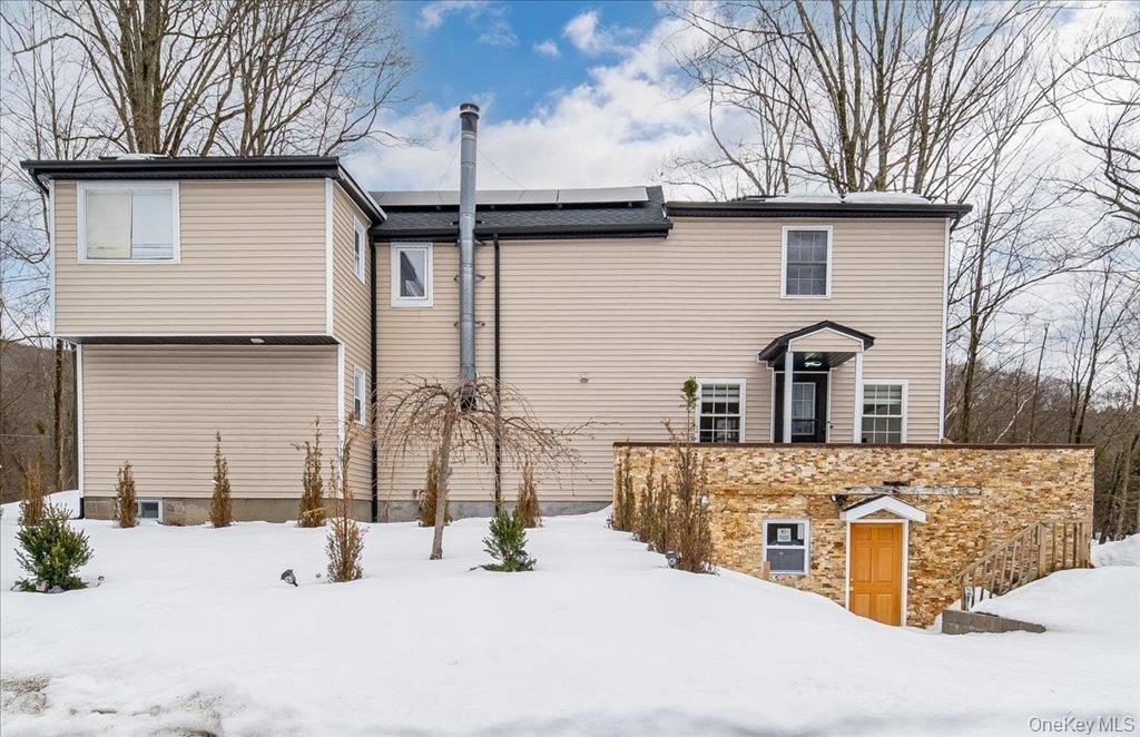 The front of the property features a brick exterior and two separate entrances: one on the main floor and another leading to the basement.