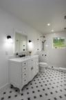 Hallway Bathroom featuring toilet, tiled shower, vanity, and recessed lighting