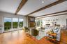 Living area with hardwood / wood-style floors, beam ceiling, a stone fireplace, and recessed lighting