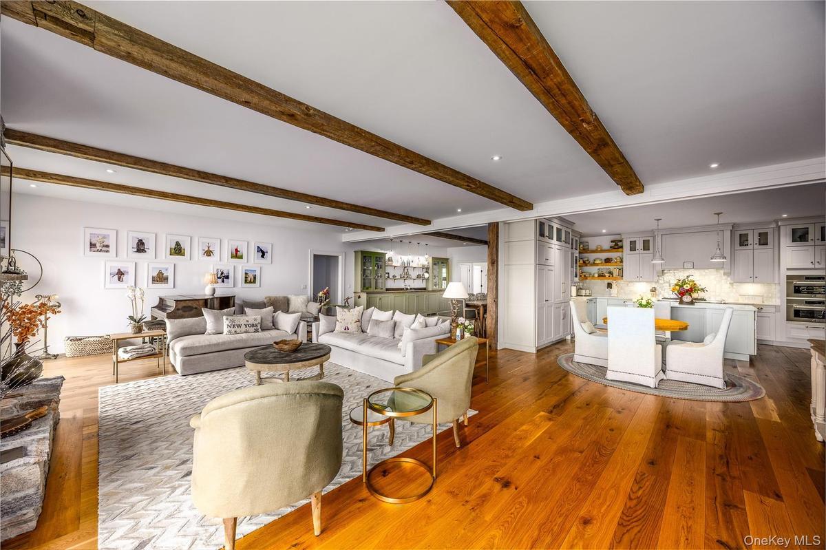 Living room featuring beamed ceiling, wood finished floors, and recessed lighting
