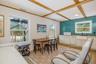 Dining space featuring healthy amount of natural light, light wood-type flooring and beam ceiling