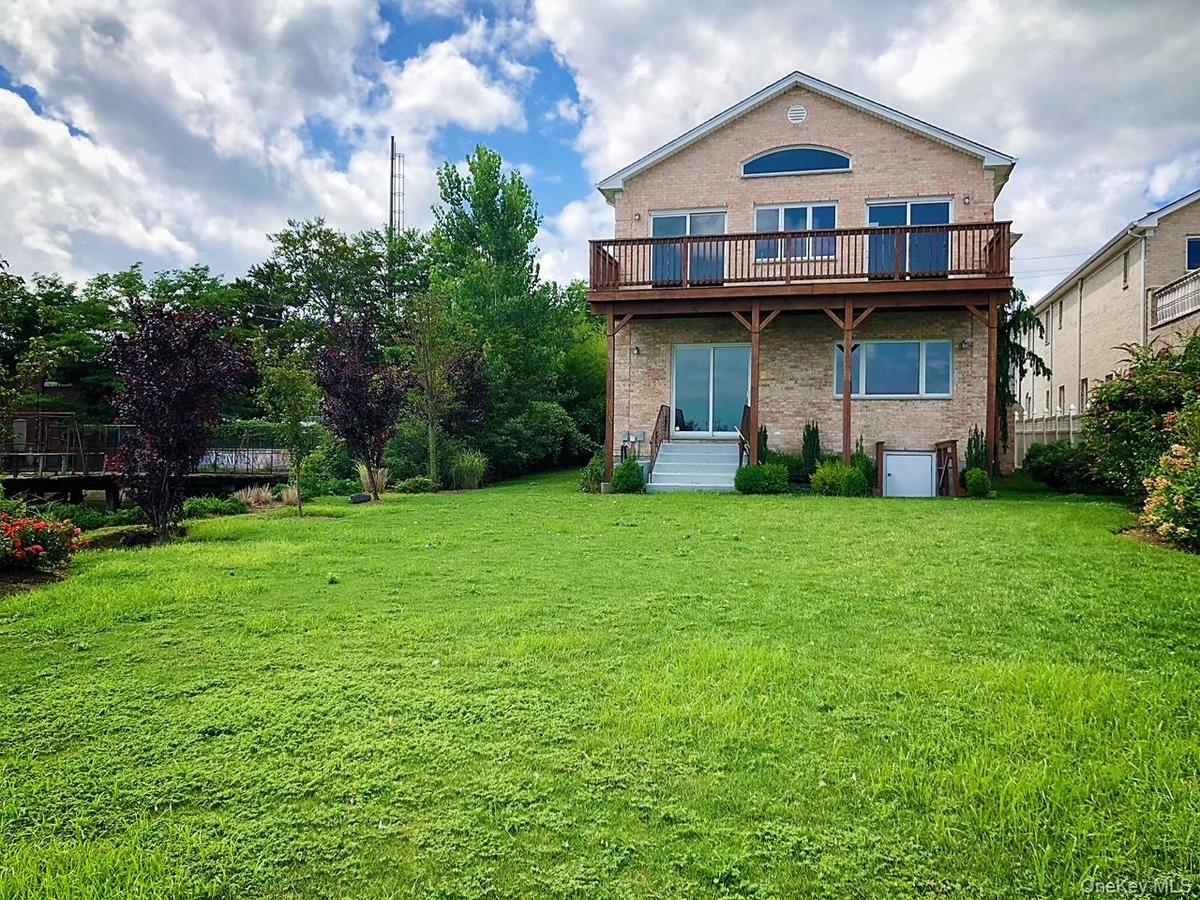Rear view of house with brick siding and a yard