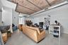 Living area with finished concrete flooring, a desk, and brick ceiling