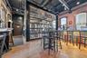 Community bar area with brick wall, a towering ceiling, and finished concrete flooring