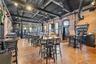 Dining room featuring brick wall, finished concrete flooring, and a towering ceiling