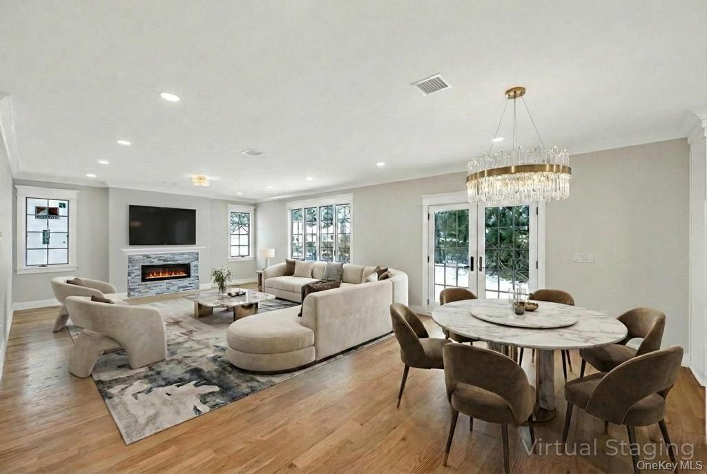Open layout dining and living room with fireplace.  Virtual staging