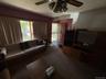Carpeted living room with ceiling fan