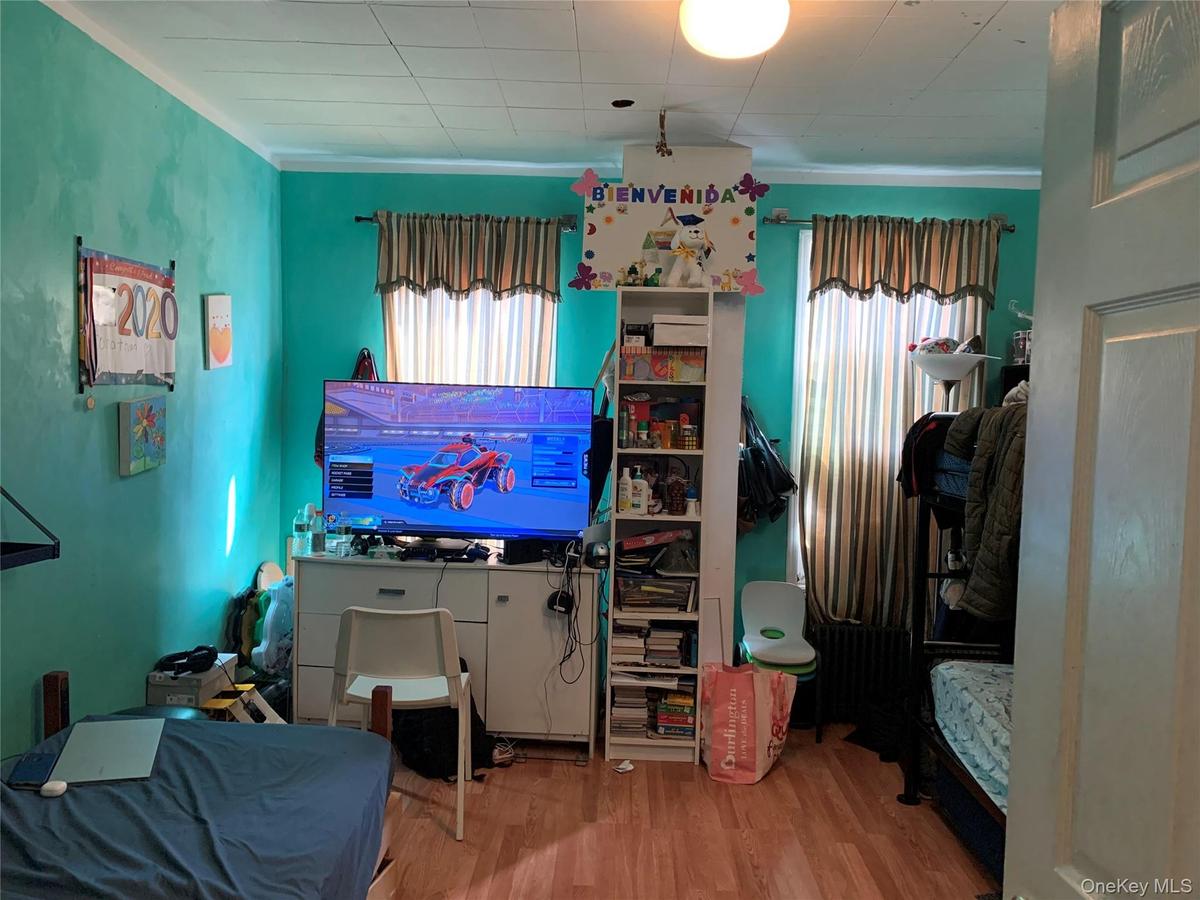 Bedroom featuring wood finished floors and ornamental molding