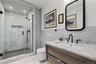 En-Suite Bath – Marble and herringbone tile with premium, wall-hung fixtures.