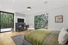 Primary Suite View – Walls of glass bring in natural light and greenery.