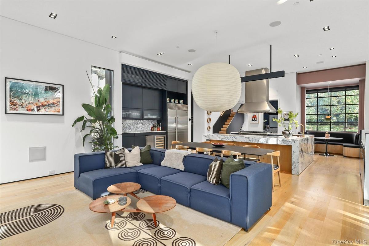 Bright, airy living spaces framed by black steel casement windows and natural light.