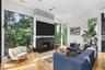 Living Room – Sleek gas fireplace with stone mantel and built-in media wall, oversized windows creates a warm modern retreat